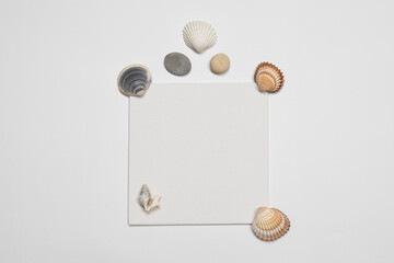 Invitation or Flyer blank card mockup with seashells and stones decoration. Summertime memories template elegant paper card note with creative copy space.