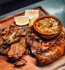Grilled sliced beef steak on a black cutting board on the wooden table.