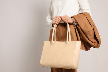 Young woman with stylish bag on white background, closeup
