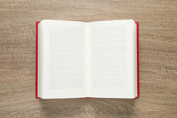 Open book on wooden table, top view