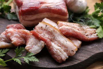 Pork fatback and fresh parsley on wooden table, closeup