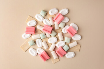 Many different chewing gums on beige background, flat lay