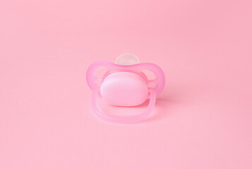 One new baby pacifier on pink background