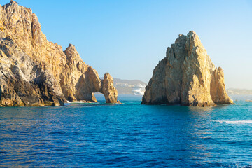 A cruise ship is in view behind the famous El Arch, the Arch, at the Land's End region on the Baja Peninsula at Cabo San Lucas, Mexico.