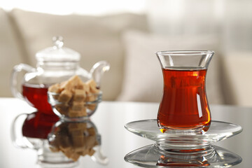 Glass of traditional Turkish tea on table indoors, space for text