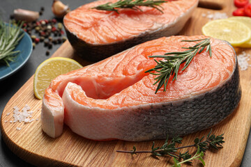 Fresh salmon and ingredients for marinade on wooden board, closeup