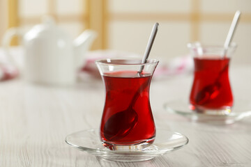 Glasses of traditional Turkish tea on white wooden table indoors