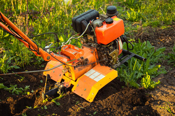 a small agricultural tractor plows the ground, the work of a walk-behind tractor. land treatment for planting.