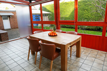 Wooden table with fruits and stylish chairs on terrace