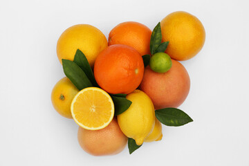 Different citrus fruits and leaves on white background, top view