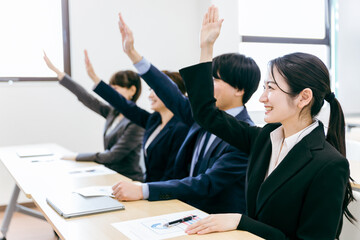 オフィス・会議室で挙手して積極的に質問・意見・発言するビジネスウーマン・会社員の男女（セミナー）