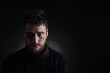 Man with bruise on dark background, space for text. Hostage