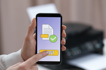 Man using printer management application on mobile phone in office, closeup