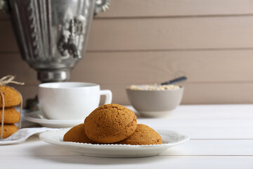 Delicious oatmeal cookies on white wooden table