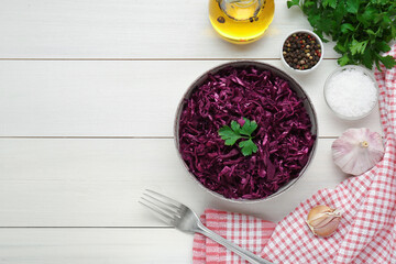 Tasty red cabbage sauerkraut with parsley and different ingredients on white wooden table, flat lay. Space for text