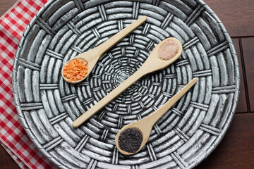 poppy seeds, pink lentils and pink himalayan salt in spoons and handmade plate