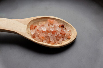 pink himalayan salt in spoons and black plate