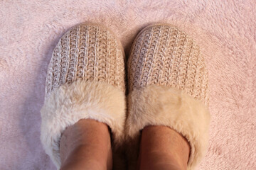Pale pink slippers with a plush carpet background