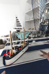 Barca de artesania en miniatura en cuarto ordenado con articulos de navegacion, mar y pesca