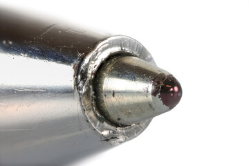Extreme close up shot of tip of ball point pen on white background. Focus stacked image.