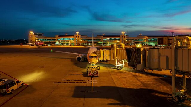 Don Muang Airport,THAILAND NOV 2022 : Time lapse ground staff Preparing the aircraft before flight. Loading of baggage Food for flight services and equipment before boarding at night time, 4K Res..