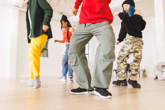 Image of low section of group of group of diverse female and male hip hop dancers in studio