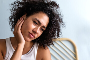 Young multiracial woman touching ear in pain. Latina female suffering from otitis. Body care...
