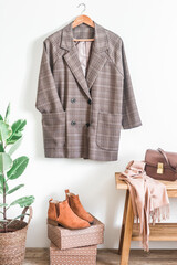 English style  checkered jacket in , red leather chelsea, cashmere scarf, leather bag in the interior of the room in scandinavian style