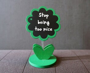 Tree chalkboard with handwritten reminder  STOP BEING TOO NICE, concept of stop being people...