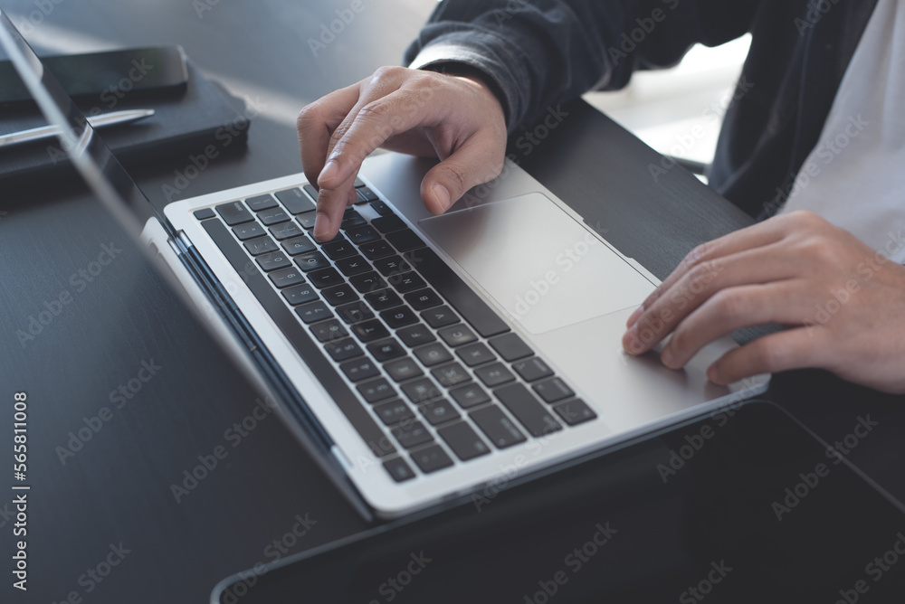 Wall mural close up of man hands working, typing on laptop computer, browsing the internet, networking at home 