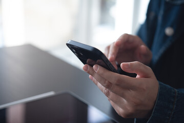 Close up of business woman hand using mobile phone, searching the information during online working on digital tablet on office table, internet networking, business planning, social media marketing