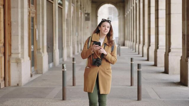 Young tourist woman checking map on cell phone gps app - Visiting historical European city in winter vacations