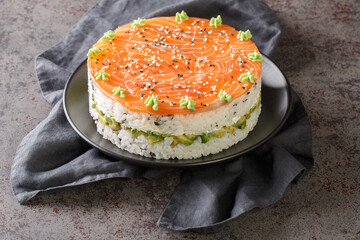 trend food Sushi cake with lightly salted salmon, nori, avocado and philadelphia cheese closeup on...