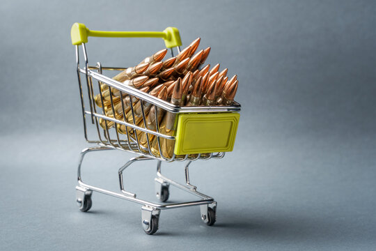 Rifle cartridges in a shopping cart. 223 caliber ammo cartridges and a small shopping basket. Three quarter view