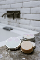 Obraz na płótnie Canvas Hand made vegan natural soap bar with herbs on bathroom background close-up. Spa organic treatments products. 