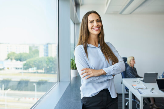 Portrait of female business owner in office. Successful businesswoman standing at modern office