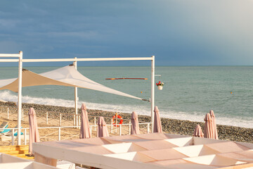 beach with bungolos and sun loungers on the sea