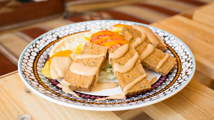 African combo plate with rice, fried cheese, grilled vegetables, peanut sauce and other traditional products.