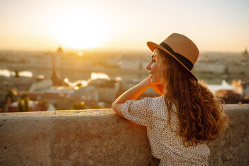 Young female tourist  looking at panoramic view of  the city at sunset. Lifestyle, travel, tourism,...