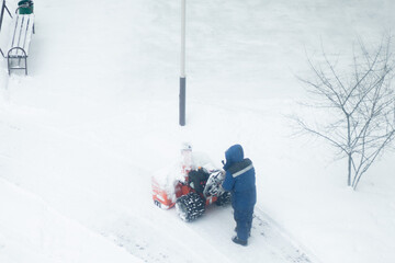 snow removal machine snow blower at the worker on the street
