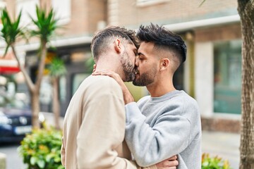 Fototapeta premium Young couple hugging each other kissing at street