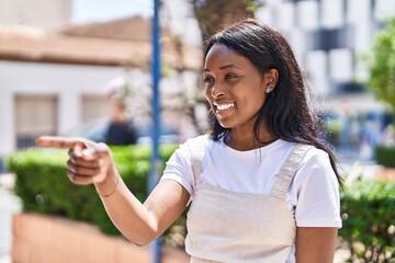 Young african american woman smiling confident pointing with finger at park