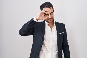 Handsome business hispanic man standing over white background doing ok gesture with hand smiling,...