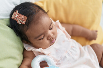 African american baby sitting on bed with relaxed expression at bedroom