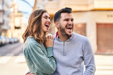 Man and woman smiling confident hugging each other standing at street