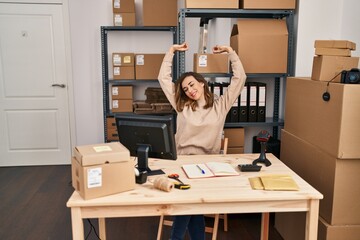 Young woman ecommerce business worker stretching arms at office