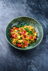 Traditional Moroccan vegetable couscous with zucchini and paprika served as close-up on a Nordic Design bowl with copy space