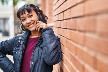 Young beautiful hispanic woman smiling confident talking on the smartphone at street