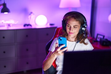 Young beautiful hispanic woman streamer using computer and smartphone at gaming room