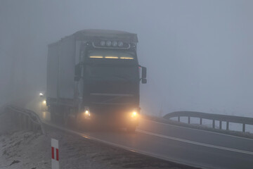 Samochody we mgle gęstej na drodze wieczorem. Niebezpiecznie.